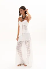 Pollera larga de encaje blanco con diseño de capas y transparencia, de corte fluido y estilo romántico.