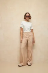 Pantalón sastrero de tiro alto, corte recto y holgado, con bolsillos laterales y cierre frontal con botón a tono.