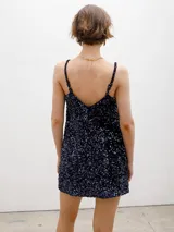 Minivestido negro con lentejuelas, de corte recto y breteles finos.