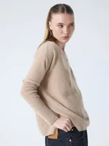 Suéter poncho de mujer, color gris claro, tejido en cashmere, con cuello en V, mangas largas acanaladas y aberturas laterales.