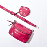 Bandolera fucsia de cuero sintético con correa ajustable y monedero circular extraíble.