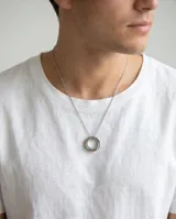 Collar de acero con dije compuesto por tres aros entrelazados, uno de ellos con detalle de esmalte multicolor. Cadena de eslabones finos.