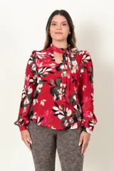 Blusa roja con estampado floral, escote en V con lazo en el cuello y mangas largas con frunces en los hombros.