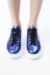 Zapatillas deportivas azules de piel metalizada con cordones negros, suela de goma blanca y detalle de rayo bordado en el lateral.
