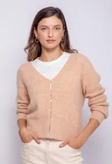 Cárdigan color durazno de tejido de punto con escote en V y cierre frontal con botones.