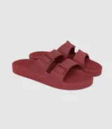 Sandalias planas color ladrillo, con doble tira ancha sobre el empeine y plantilla anatómica. Fabricadas en Brasil con materiales veganos y procesos sostenibles.