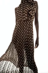 Vestido midi de color marrón con estampado de lunares blancos, cuello halter con lazo y diseño plisado.