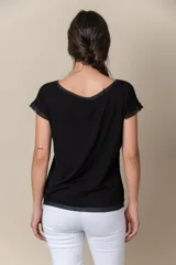 Remera de viscosa y algodón en color negro, con terminaciones de gasa en el cuello, las mangas cortas y el ruedo.