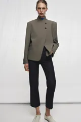 Blazer de cuello subido con cierre frontal cruzado de botones. Presenta manga larga con hombreras y puños con botones, bolsillos de vivo en el delantero y forro interior.