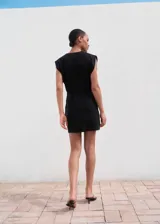 Vestido corto negro sin mangas, con escote en V cruzado, tirantes anchos y falda cruzada.