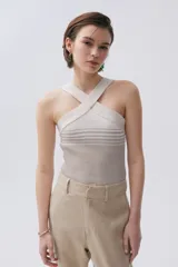 Pantalón chino color beige confeccionado en lino metalizado, de tiro medio-alto y pierna recta. Cuenta con bolsillos laterales y en la espalda.