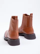 Bota tipo Chelsea de símil cuero color suela, con plataforma oscura, punta cuadrada y paneles elásticos laterales.