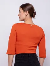 Top de manga tres cuartos con cuello redondo y detalle de aberturas cut-out en el escote.