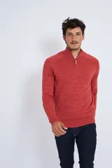 Buzo de tejido de punto color terracota con cuello elevado y cierre frontal parcial. Presenta mangas largas y ajuste regular.