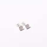 Par de caravanas plateadas con forma circular y pequeños brillantes incrustados.