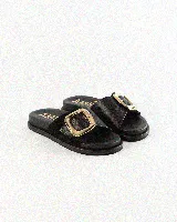 Sandalias de cuero color negro, de diseño plano con una tira ancha en el empeine y una hebilla metálica dorada grande como detalle.