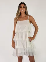 Vestido corto blanco de tirantes finos con diseño de múltiples volados en capas horizontales.