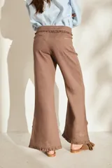Pantalón morado de corte acampanado con volados decorativos en la cintura y en el ruedo.