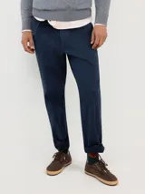 Pantalón chino de corte regular fit, confeccionado en gabardina con acabado desgastado. Presenta bolsillos laterales y traseros, con cierre de botón y cremallera.