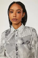 Camisa blanca con estampado de pata de gallo en negro, abotonada en el frente y de corte recto.