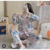 Conjunto de pijama de dos piezas compuesto por una camisa de manga larga con cuello mao y cierre frontal de botones, y un pantalón largo. Presenta un diseño estampado de corazones sobre fondo negro con detalles en color blanco.
