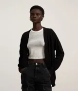 Cardigan de punto básico, con mangas largas y sisa desplazada. Presenta un diseño abierto sin botones, confeccionado en un tejido de punto ligero y versátil.