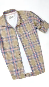 Camisa leñadora de algodón peinado a cuadros beige, rosa y lila, de manga larga con puños abotonados y cuello clásico.