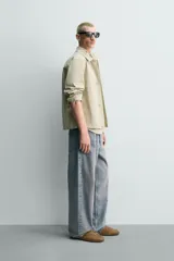 Sobrecamisa de corte regular fit en color beige, confeccionada en popelín de algodón. Cuenta con cuello solapa, manga larga con puño abotonado, bolsillos ocultos en las costuras de la cadera y cierre frontal con botonadura oculta.