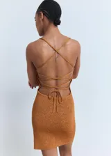 Vestido corto de tejido de punto con lúrex, color cobre, de corte entallado con escote cuadrado y tirantes finos. Presenta un diseño de espalda descubierta con cierre de lazo cruzado.