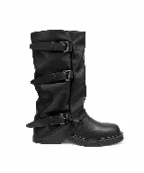 Bota alta de cuero sintético negro con diseño slouchy y tres tiras con hebillas metálicas en el lateral. Suela plana y puntera redondeada.