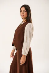 Chaleco marrón con escote en V, sin mangas y cierre frontal con botones.