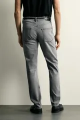 Jeans slim fit de color negro para hombre, con tiro medio, diseño de cinco bolsillos y cierre frontal con cremallera y botón.