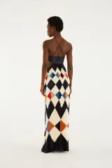 Vestido largo plisado con estampado geométrico de rombos en tonos negro, blanco, azul, rojo y naranja. Cuenta con escote halter con finos tirantes, diseño strapless con fruncido en el centro del busto y aberturas laterales en la cintura.