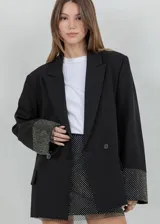 Blazer oversize negro con solapas de muesca, cierre de doble botón frontal y puños decorados con rhinestones plateados.