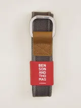 Cinturón gris de tela con hebilla metálica doble cuadrada.