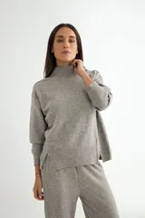 Conjunto de dos piezas compuesto por un sweater de cuello alto con aberturas laterales en el ruedo y un pantalón de corte recto y holgado, ambos confeccionados en tejido de punto suave.