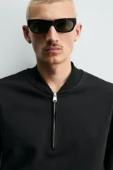 Sudadera de corte regular fit confeccionada en tejido de algodón con interior de rizo. Presenta cuello tipo rib, cierre frontal de cremallera y acabados en rib en puños y bajo.