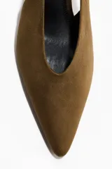Zapatos destalonados de tacón kitten color marrón con acabado efecto ante y punta fina. Cuenta con tira elástica en el talón.