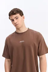 Remera de manga corta color beige con tejido texturado y pequeño logo impreso en el pecho.