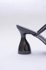 Sandalias plateadas con taco de forma geométrica y tiras transparentes.