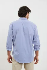 Camisa celeste con rayas verticales blancas, de manga larga con puños abotonados y cuello clásico.