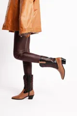 Bota tejana de cuero color marrón claro con puntera fina, caña media con bordados en negro y blanco, y taco bajo.