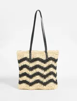 Bolso playero tipo tote de papiro color beige con diseño de zig zag negro y asas de cuero sintético negro.