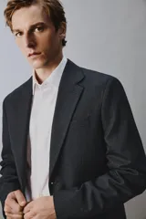 Blazer de corte regular confeccionada en lana de origen italiano, con diseño a cuadros sutiles. Presenta cuello con solapas de muesca, cierre frontal de un botón, bolsillos laterales con solapa y bolsillo en el pecho. Cuenta con aberturas en la espalda y forro interior.