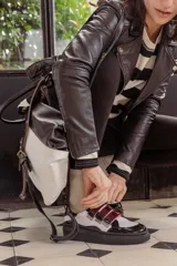 Zapatillas de plataforma color blanco con detalles en charol negro y rojo. Presentan ajuste con tiras de velcro.