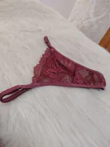 Microtanga confeccionada en encaje floral color bordó, con tiras laterales regulables y terminaciones en el mismo tono.