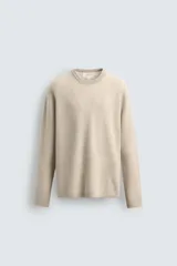 Jersey de punto canalé con cuello redondo y manga larga, confeccionado en hilatura de cashmere. Presenta un corte regular fit con acabados en rib en puños y bajo.