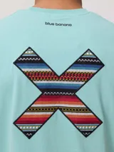 Remera de algodón orgánico color blanco, con corte regular fit y detalle de bordado en forma de X con diseño geométrico multicolor en el pecho.