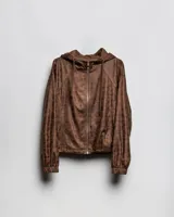 Campera cropped tipo bomber color marrón con acabado vintage, capucha con cordón ajustable, cierre frontal y puños y ruedo elásticos.