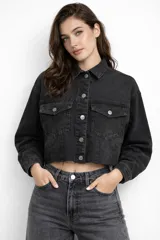 Campera de jean tipo crop top, color gris oscuro lavado, con cuello camisero, cierre frontal con botones metálicos y dos bolsillos frontales con solapa.